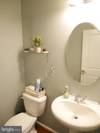a bathroom with a toilet a sink and mirror