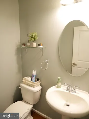 a bathroom with a toilet a sink and mirror