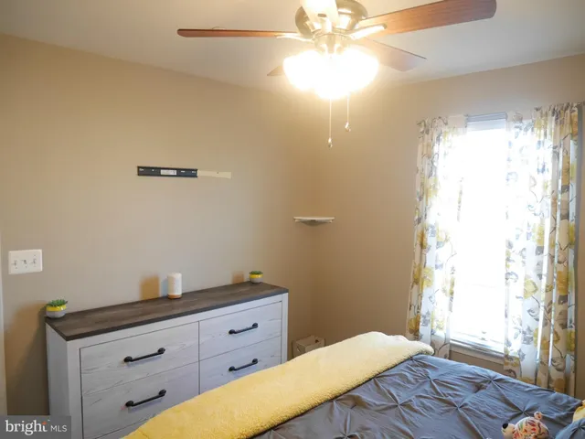 a bedroom with a bed and a chandelier fan