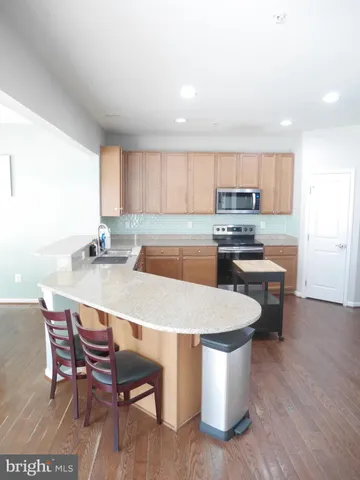 a kitchen with a table chairs a sink dishwasher window and cabinets