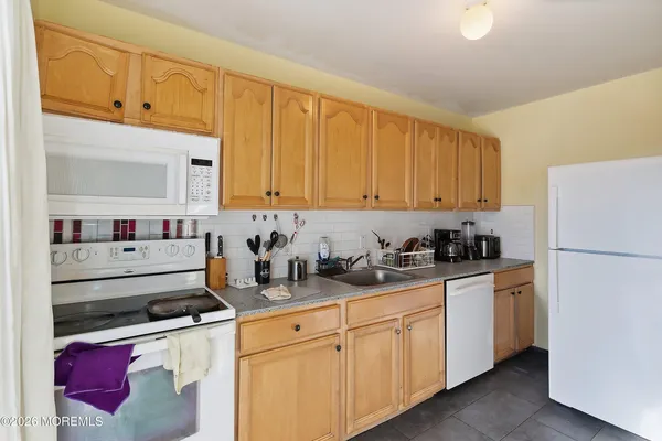 a kitchen with stainless steel appliances granite countertop a refrigerator and white cabinets