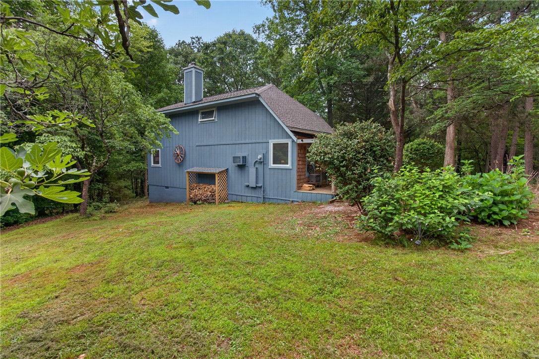 130 Maggie Rufus Lane Westminster, SC 29693 - Photo 6 of 50 A secluded residence nestled in lush trees, featuring a cozy outdoor area and ample green space.