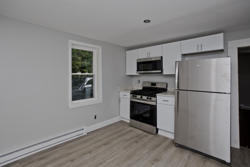 293-295 Water Street Springfield, MA 01151 - Photo 4 of 36 a kitchen with granite countertop a refrigerator stove and microwave