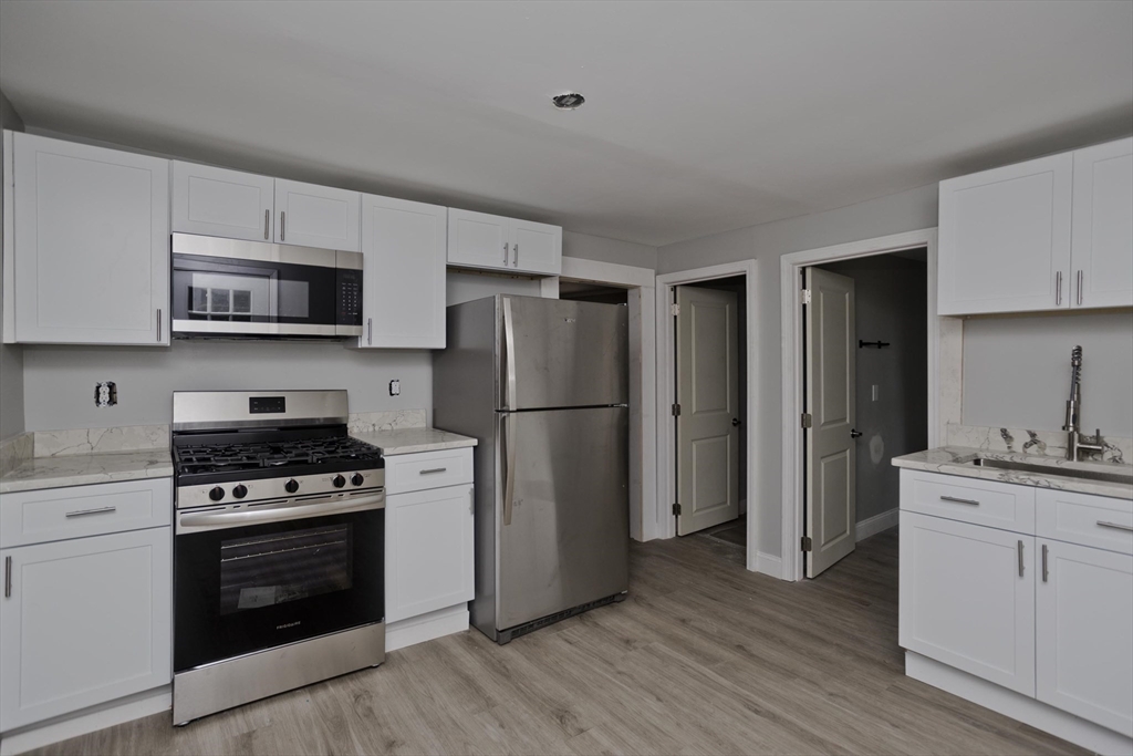 293-295 Water Street Springfield, MA 01151 - Photo 5 of 36 a kitchen with a stove a refrigerator and a sink