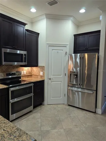 a kitchen with granite countertop stainless steel appliances and refrigerator