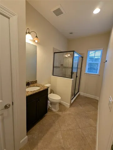 a bathroom with a granite countertop sink toilet and mirror