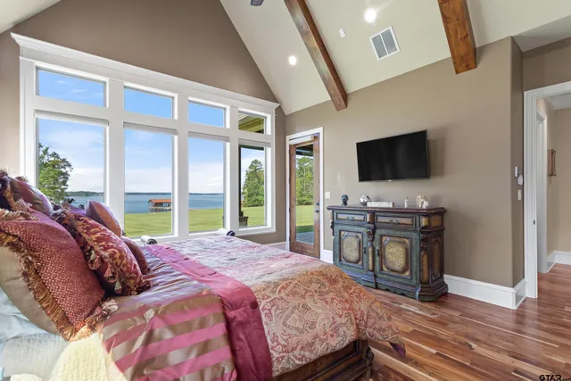a large bathroom with a double vanity sink a large mirror and a bathtub next to a window