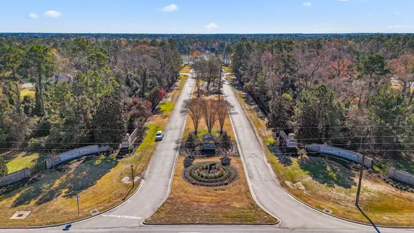 an aerial view of residential houses with outdoor space and trees