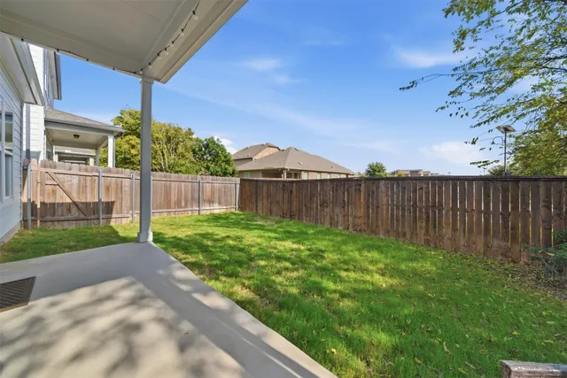 a view of a backyard with wooden fence