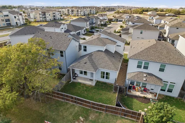 an aerial view of a house with swimming pool lawn chairs and large tree