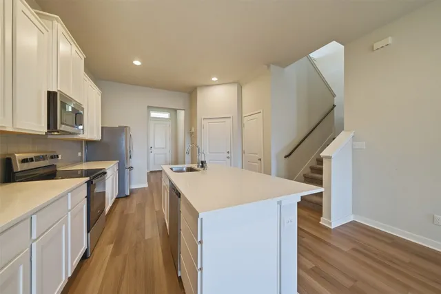 a kitchen with a sink a counter top space stainless steel appliances and cabinets