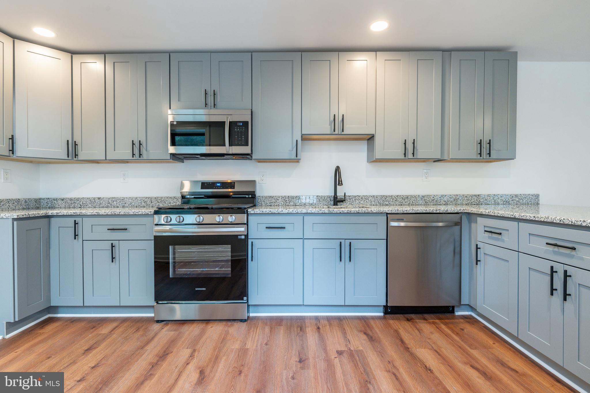 32 East Elm Street Norristown, PA 19401 - Photo 13 of 65 a kitchen with stainless steel appliances granite countertop a stove a sink and a microwave