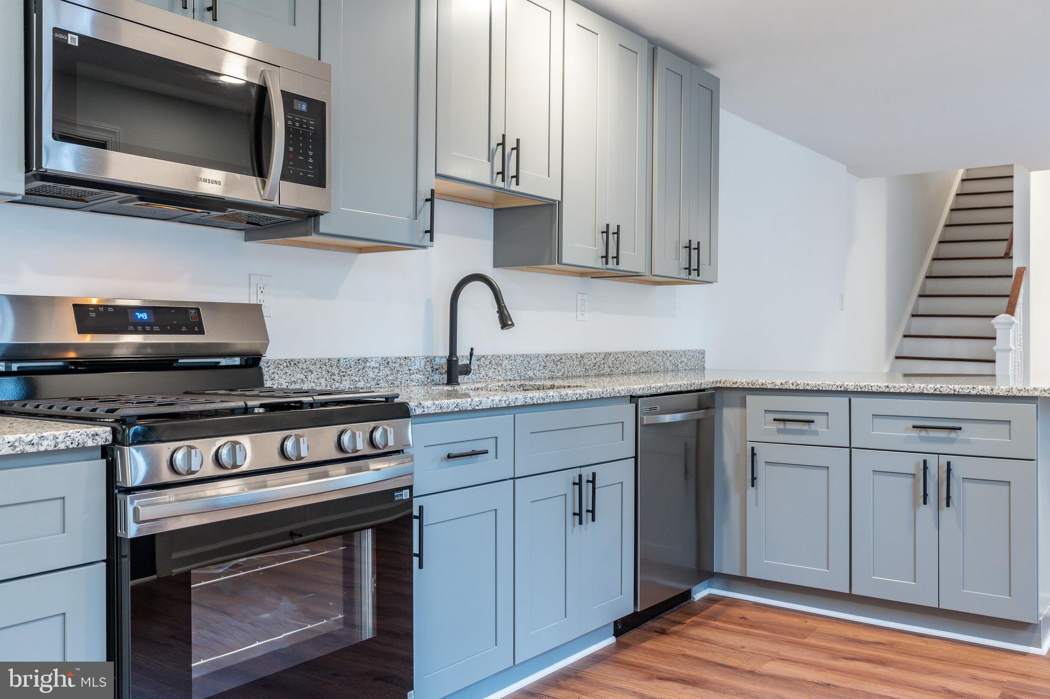 32 East Elm Street Norristown, PA 19401 - Photo 14 of 65 a kitchen with stainless steel appliances a stove a microwave a sink and cabinets