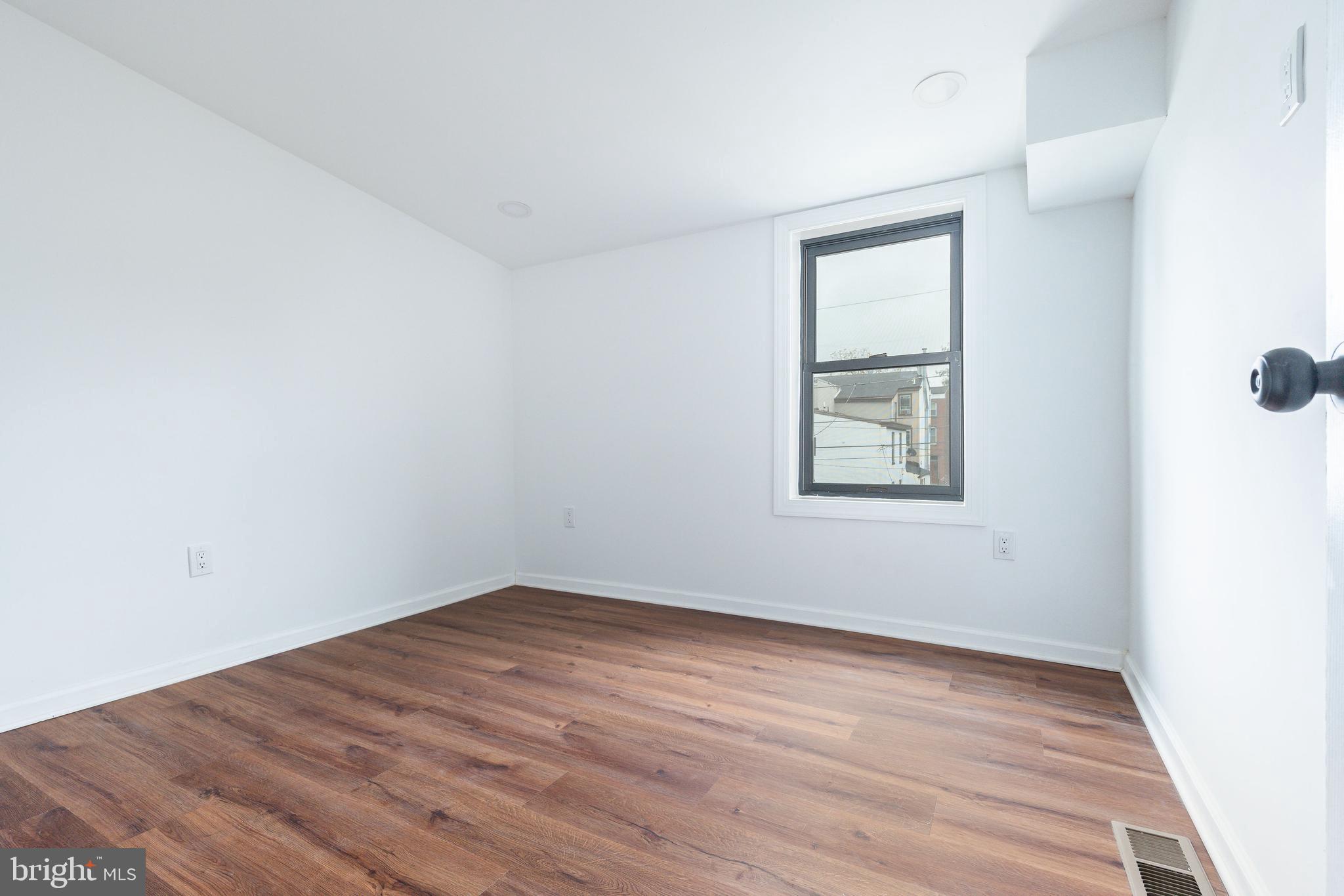 32 East Elm Street Norristown, PA 19401 - Photo 32 of 65 an empty room with wooden floor and windows