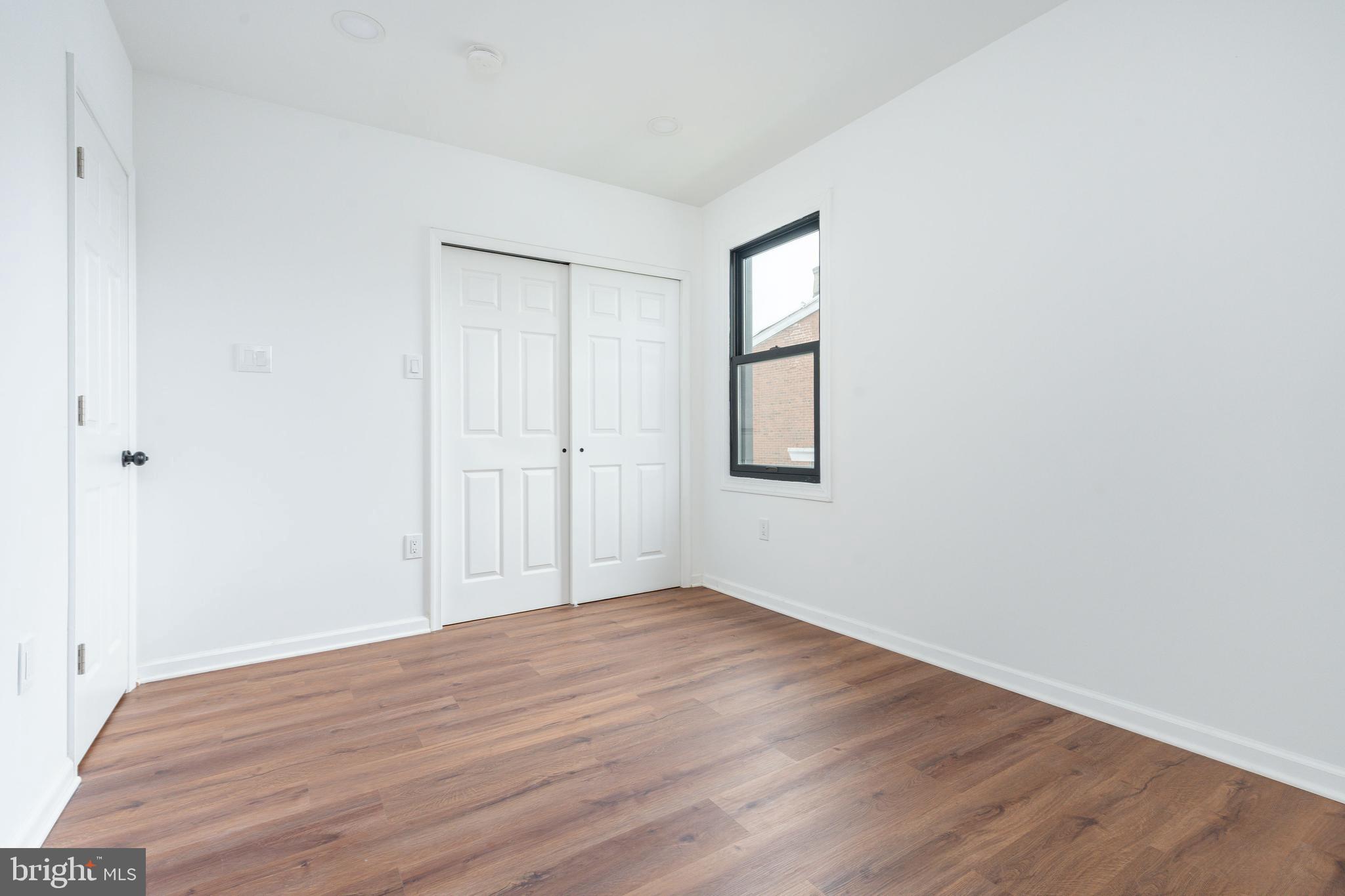 32 East Elm Street Norristown, PA 19401 - Photo 39 of 65 an empty room with wooden floor and windows