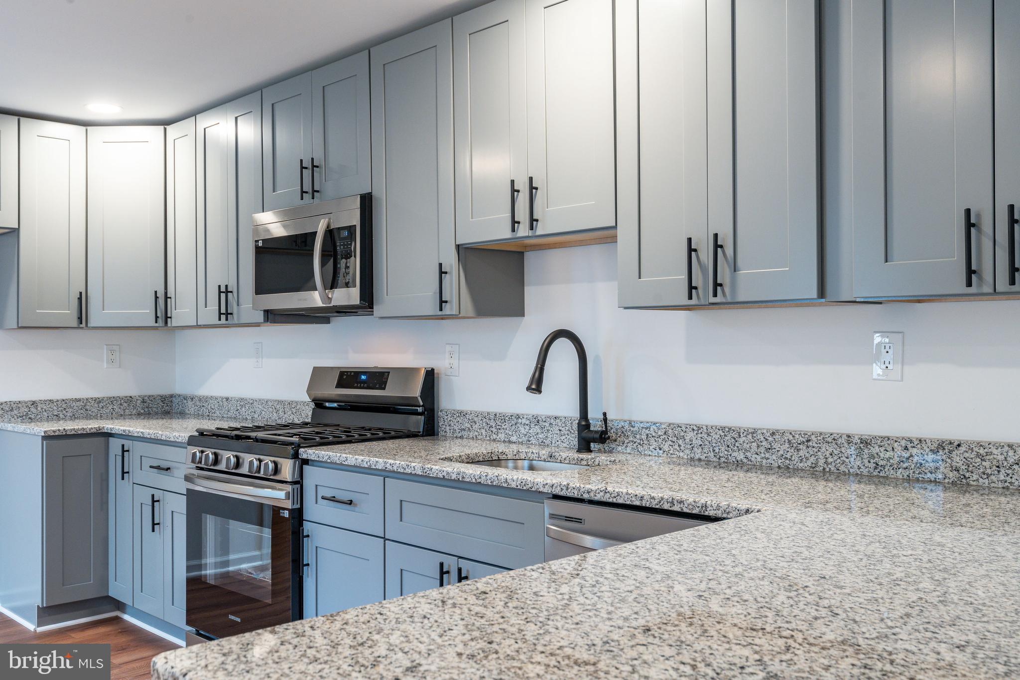 32 East Elm Street Norristown, PA 19401 - Photo 8 of 65 a kitchen with stainless steel appliances granite countertop a stove a sink and a microwave