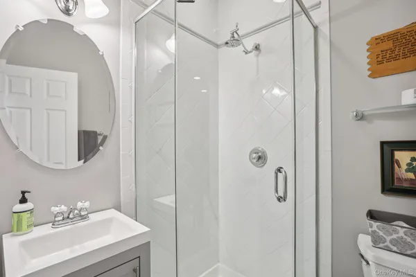 a bathroom with a sink a toilet and shower