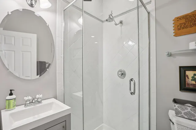 a bathroom with a sink a toilet and shower