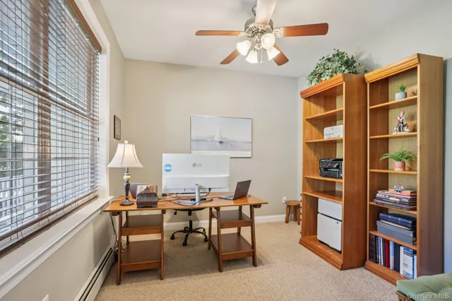a view of a workspace with furniture and a window