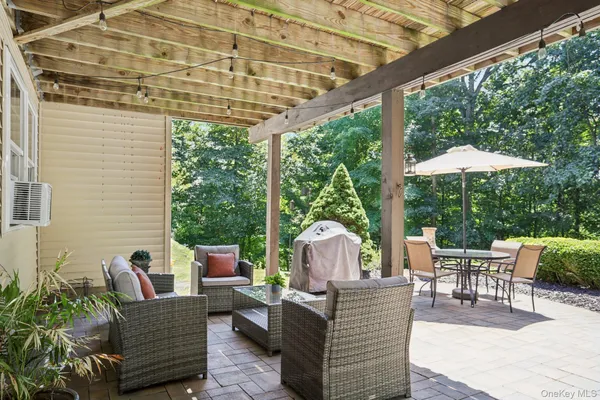 a view of a patio with couches chairs potted plants and a palm tree