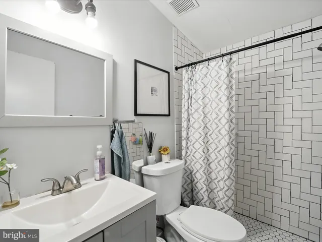 a bathroom with a sink a toilet and a mirror
