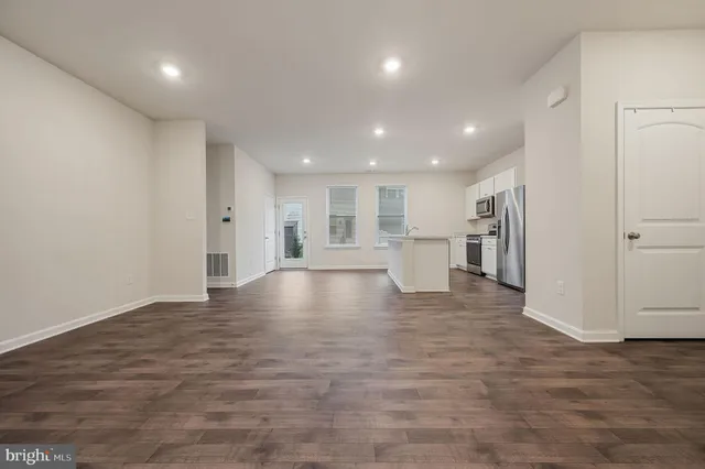 a view of empty room with wooden floor