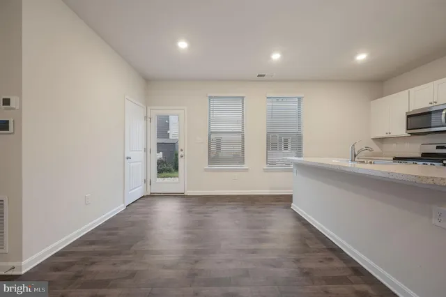 a view of kitchen with wooden floor and electronic appliances