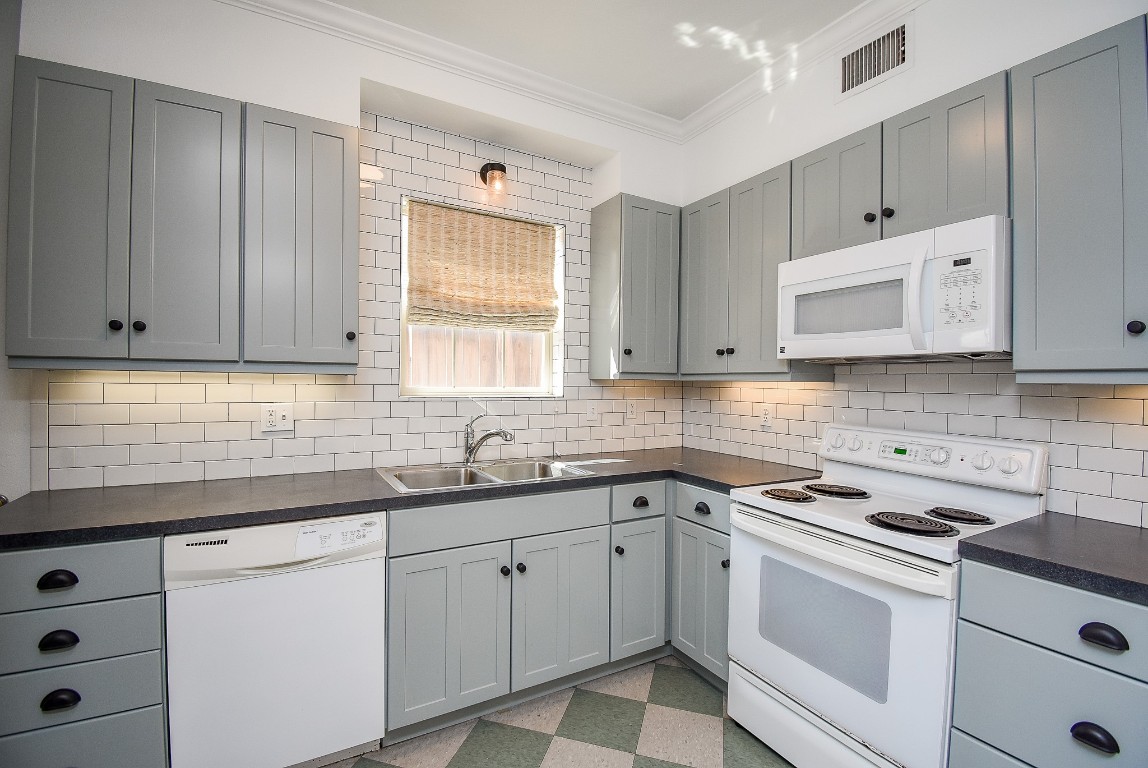 1313 Peden Street Houston, TX 77006 - Photo 20 of 33 a kitchen with cabinets appliances a sink and a window