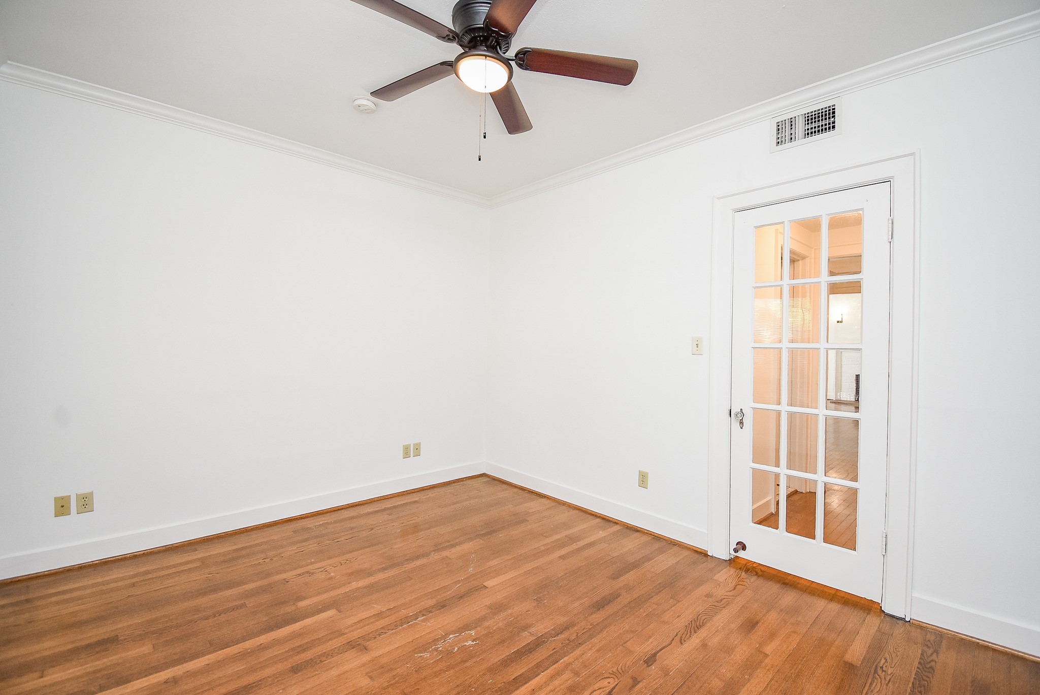 1313 Peden Street Houston, TX 77006 - Photo 23 of 33 an empty room with wooden floor fan and windows