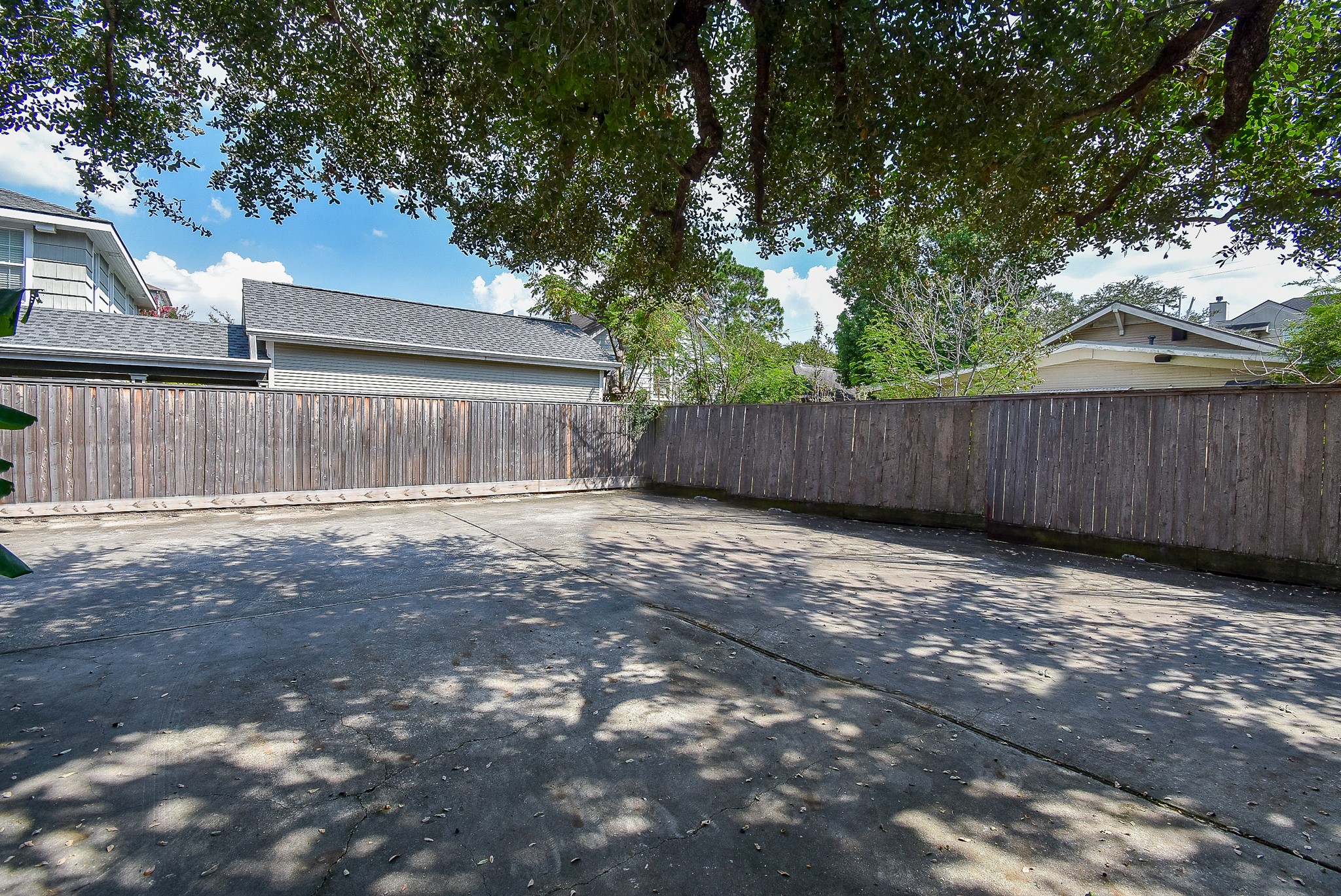1313 Peden Street Houston, TX 77006 - Photo 4 of 33 a view of a backyard with large trees and wooden fence