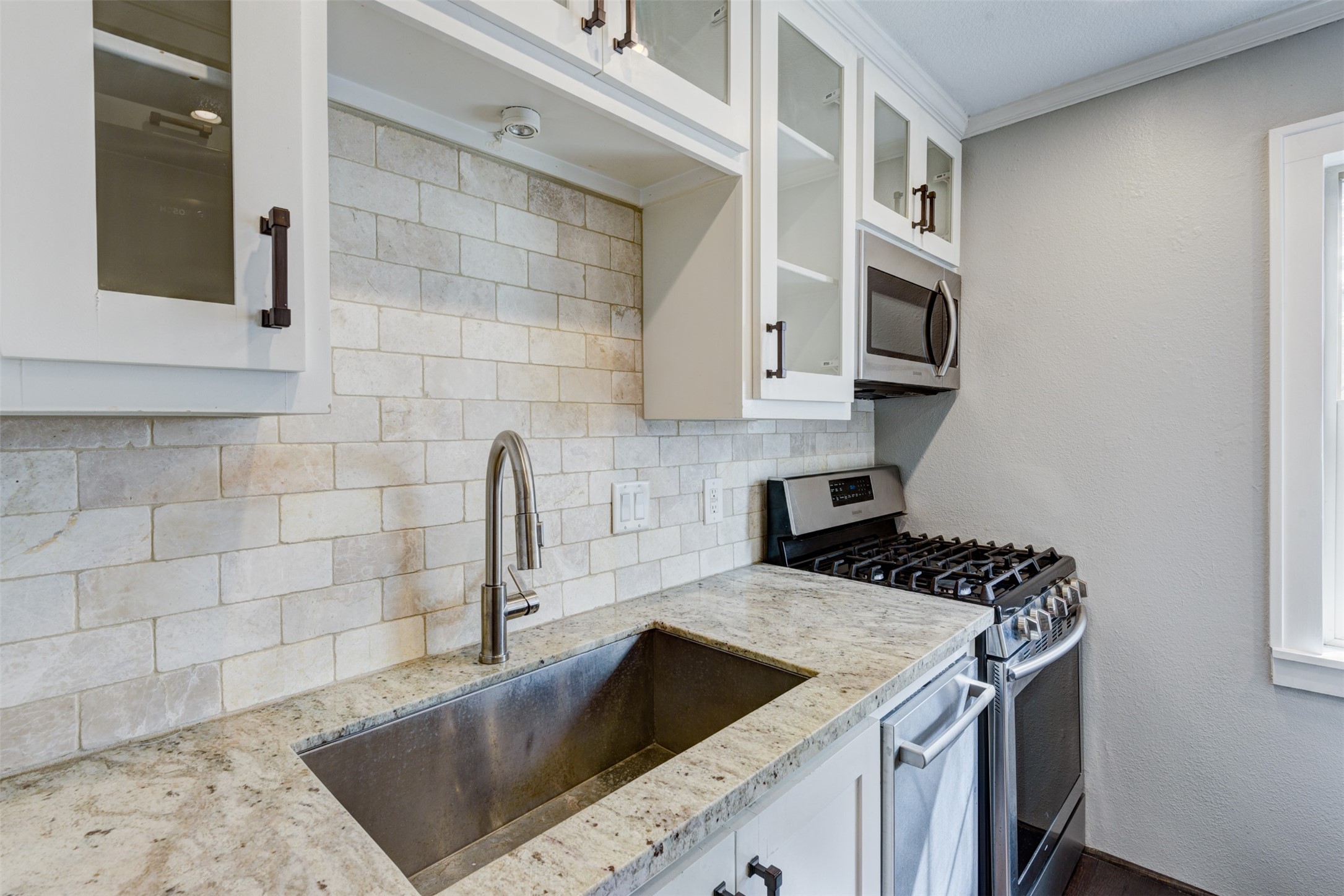1313 Peden Street Houston, TX 77006 - Photo 8 of 33 a kitchen with granite countertop a sink and a stove top oven