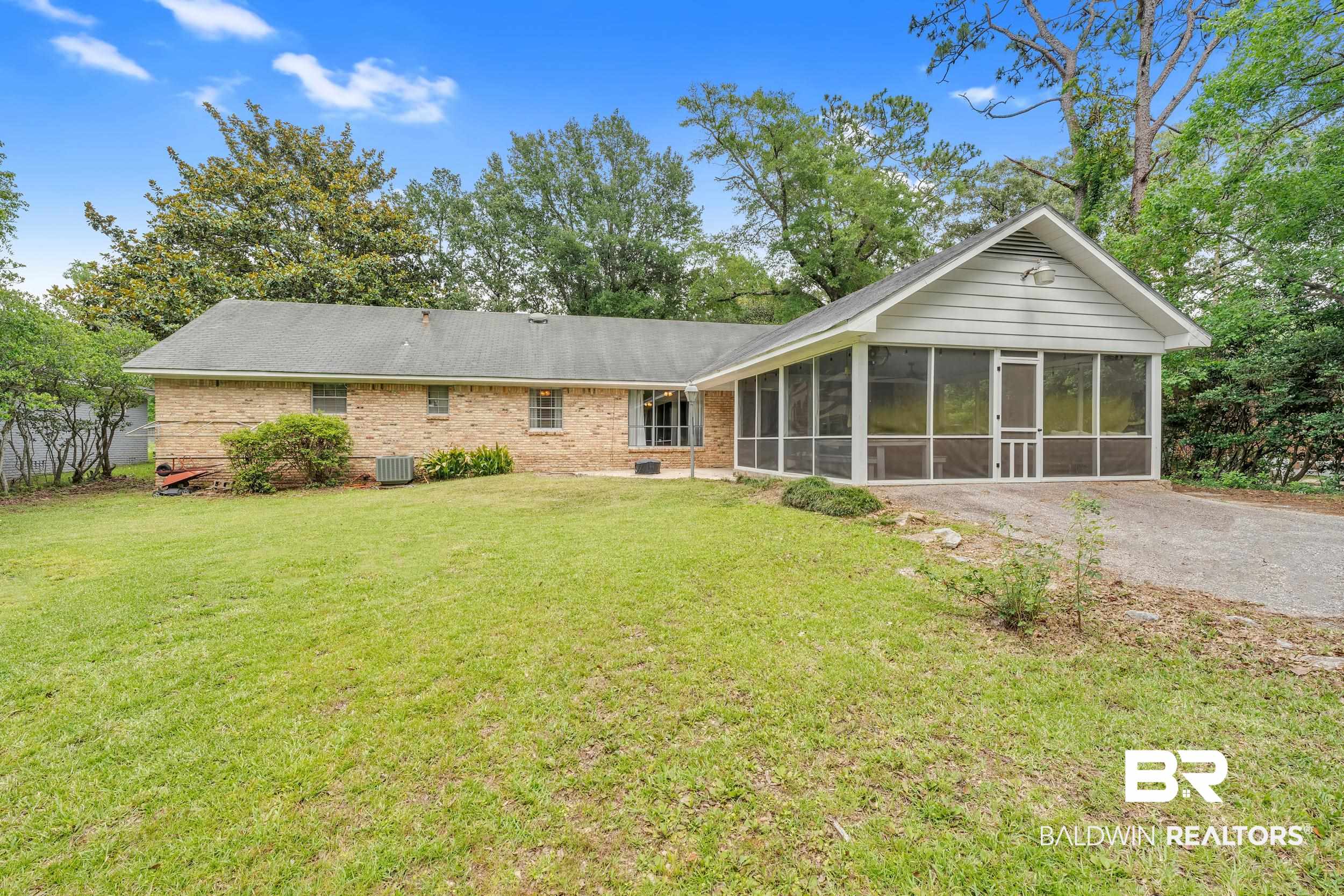 224 Cache Circle Mobile, AL 36611 - Photo 4 of 42 Rear view of house featuring a sunroom, a lawn, brick siding, and central AC