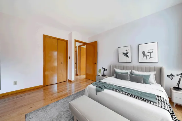 a bedroom with a bed and wooden floor