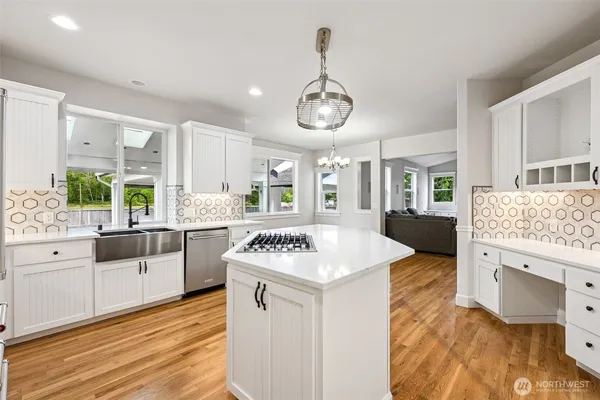 a kitchen with stainless steel appliances granite countertop a sink stove and wooden floor
