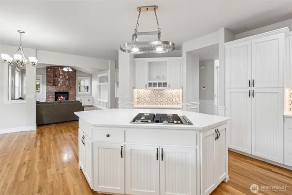 a kitchen with kitchen island granite countertop a sink a counter space and stainless steel appliances