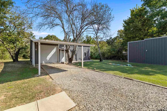 a view of a house with backyard and trees