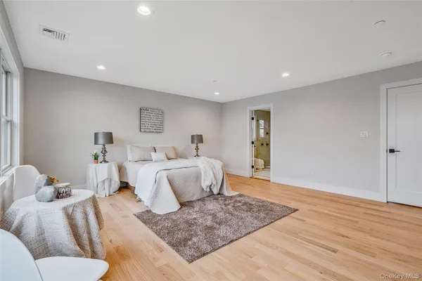 a bedroom with a large bed and wooden floor