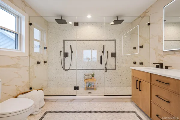 a bathroom with a shower sink mirror and toilet