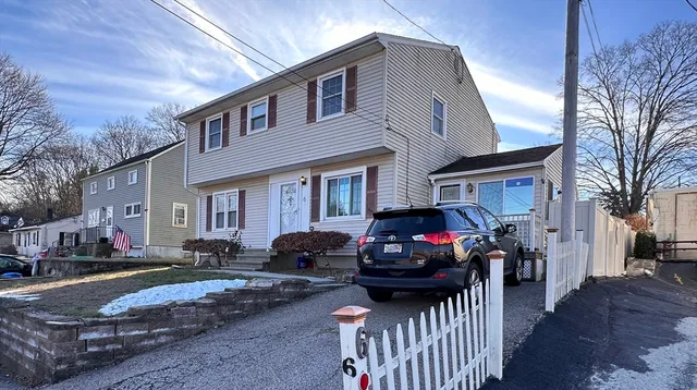 a front view of a house with cars parked