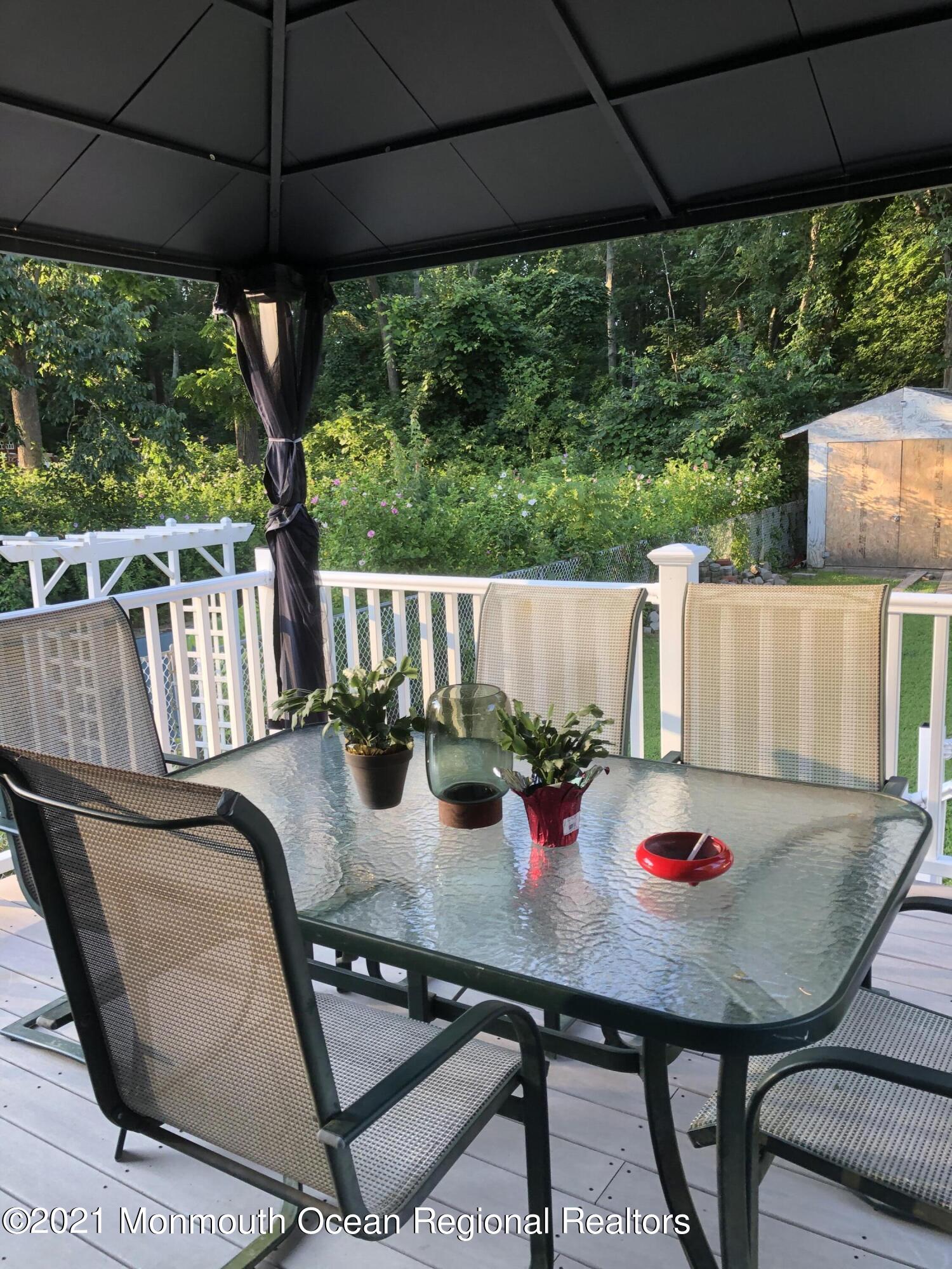 836 Wright Debow Road Jackson, NJ 08527 - Photo 21 of 22 a view of a patio with table and chairs under an umbrella