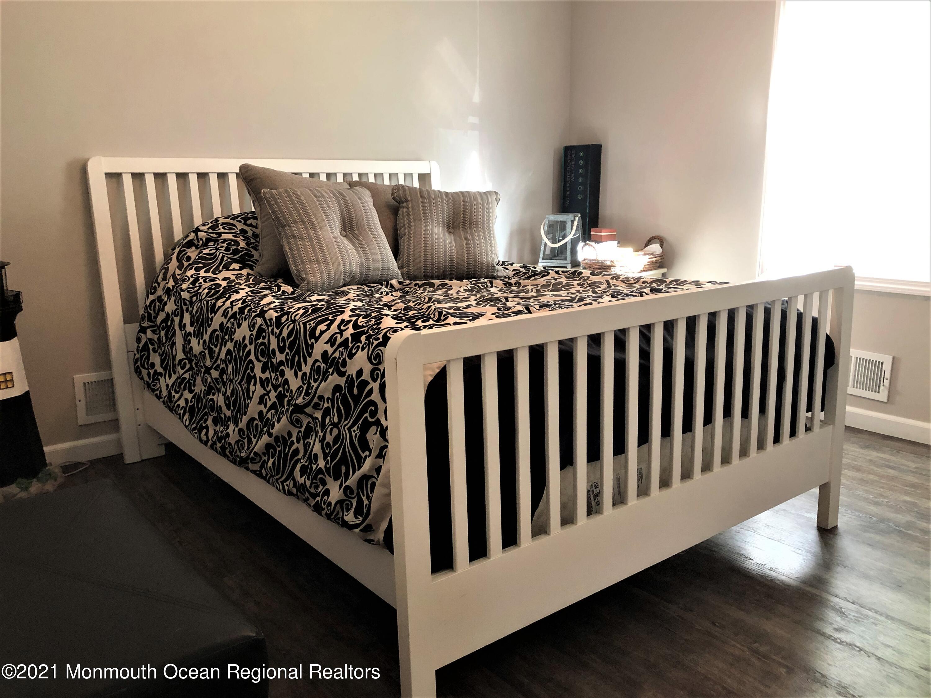 836 Wright Debow Road Jackson, NJ 08527 - Photo 10 of 22 a bed sitting in a bedroom next to a window with wooden floor