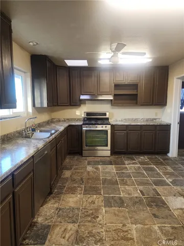 a kitchen with stainless steel appliances granite countertop a stove sink and cabinets