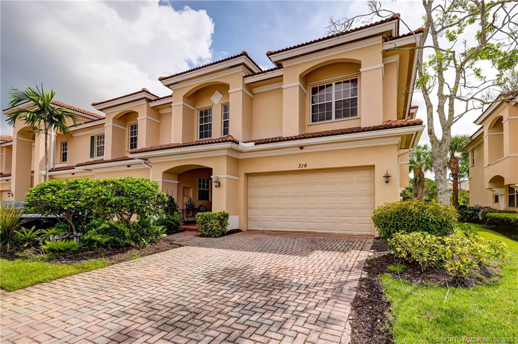 316 Southwest Otter Run Place Stuart, FL 34997 - Photo 2 of 50 a front view of a house with a yard and garage