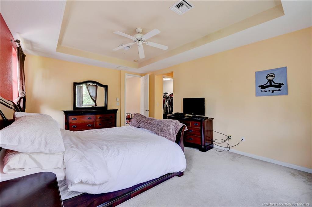 316 Southwest Otter Run Place Stuart, FL 34997 - Photo 21 of 50 a bedroom with a bed and a flat screen tv