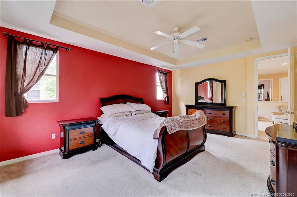 316 Southwest Otter Run Place Stuart, FL 34997 - Photo 22 of 50 a bedroom with a bed and a chandelier