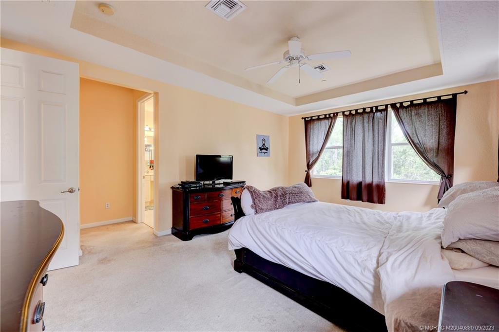 316 Southwest Otter Run Place Stuart, FL 34997 - Photo 23 of 50 a bedroom with a bed and a flat screen tv