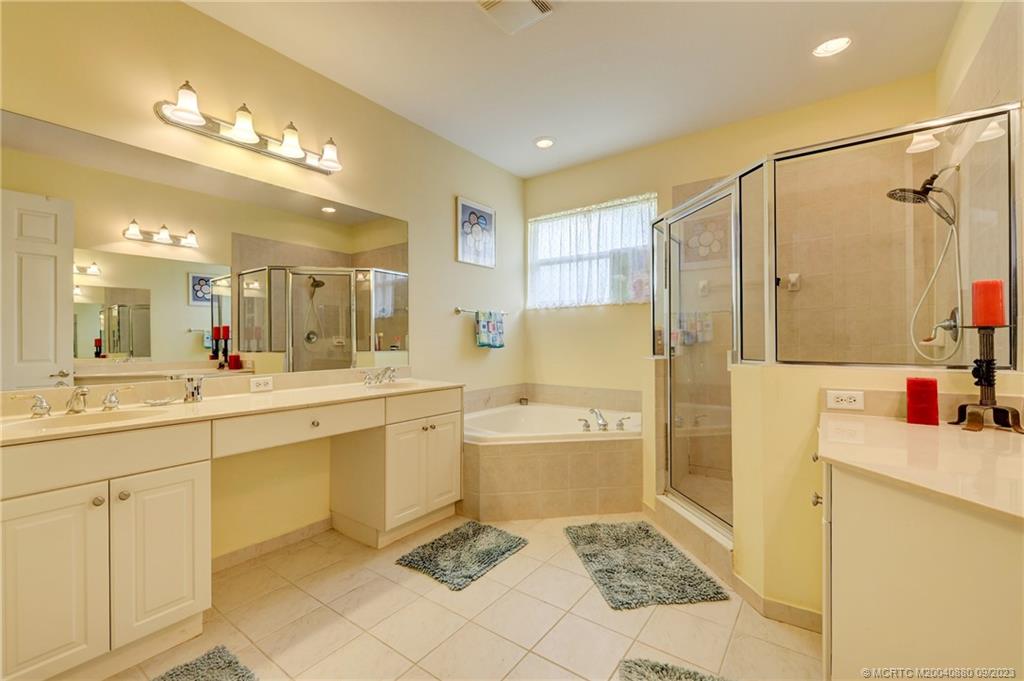 316 Southwest Otter Run Place Stuart, FL 34997 - Photo 24 of 50 a bathroom with a sink a large mirror and a shower