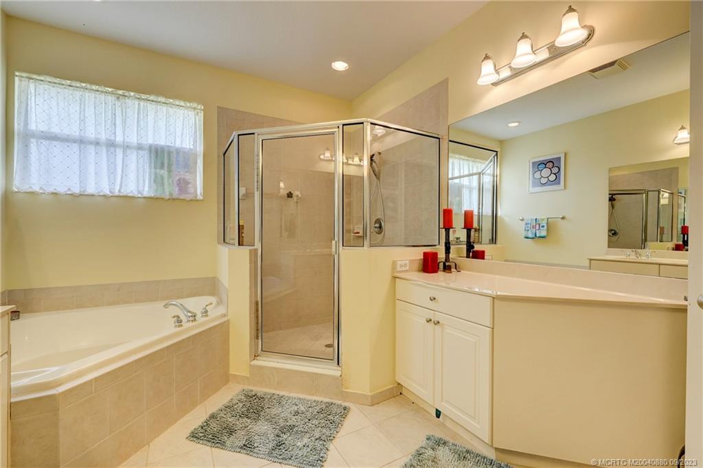 316 Southwest Otter Run Place Stuart, FL 34997 - Photo 25 of 50 a spacious bathroom with a tub sink shower and mirror