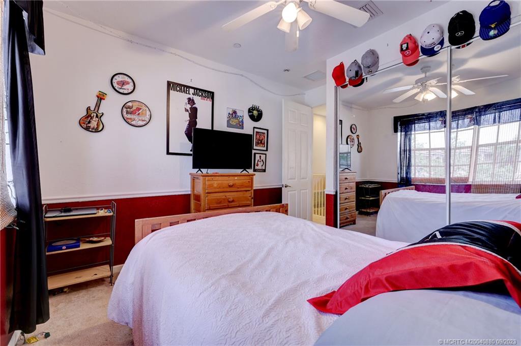 316 Southwest Otter Run Place Stuart, FL 34997 - Photo 26 of 50 a bedroom with a bed and a flat screen tv