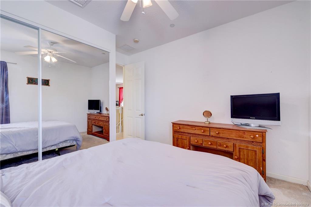 316 Southwest Otter Run Place Stuart, FL 34997 - Photo 28 of 50 a bedroom with a bed and a flat screen tv